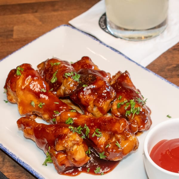 Paolo's Caribbean Fusion chicken wings, glazed in a rich sauce and garnished with parsley.